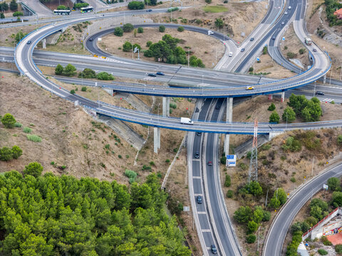 Aerial view of the A5 highway interchange featuring multi-level concrete overpasses and traffic flowing through the landscape in Cascais, Lisboa, Portugal.