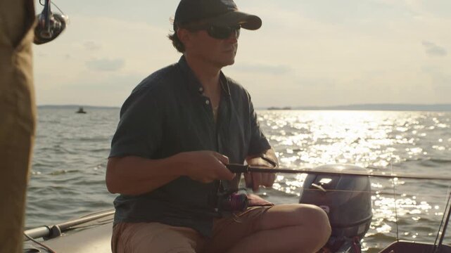 Two friends fishing on the lake from the boat