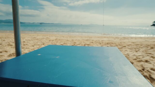 Two refreshing lime caipirinha cocktails on blue table at tropical beach shore with sunny sky and ocean waves background.