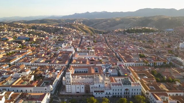 Aerial view of Sucre Bolivia white city architecture and central plaza during golden hour sunset over historic downtown.