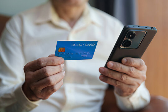 Man holding a credit card and smartphone for mobile payment and online banking, representing secure digital transactions, cashless shopping, financial technology and convenient online purchases.