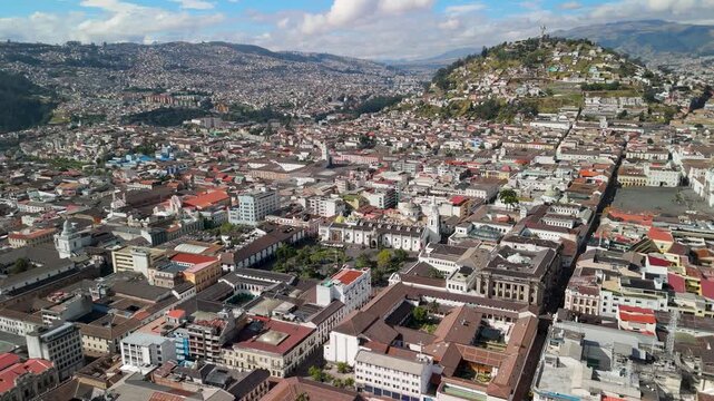 Aerial drone footage showing historic colonial city center architecture in Quito Ecuador with Panecillo hill in background.