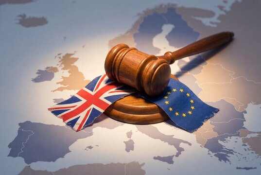 Wooden Gavel and Small Flags Representing United Kingdom and European Union on Map