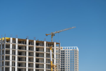 Construction reaches new heights in a vibrant city under a clear blue sky © beholdereye