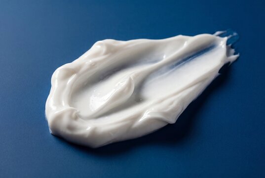 White Cosmetic Cream Smear on Deep Blue Background for Beauty Skincare Marketing