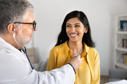 Cardiologist using stethoscope to listen patient heart beat, assessing cardiac or respiratory health during regular examination at hospital office. Cardiology, professional medical healthcare services