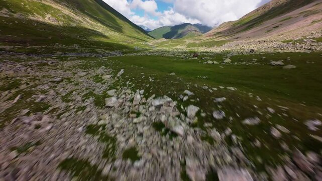 Fast forward tracking flight over green mountain valley floor