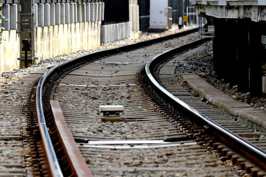 Curved railroad tracks converging at train station platform
