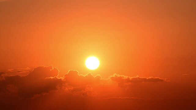 Timelapse of sun setting behind clouds in sky