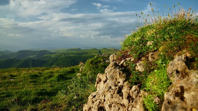 Rocky outcrop with green grass and panoramic mountain view