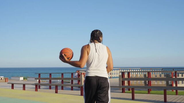 Young man playing basketball on outdoor court