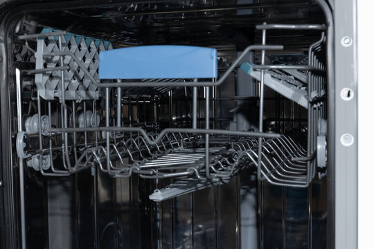 Dishwasher interior displays empty racks ready for loading dishes
