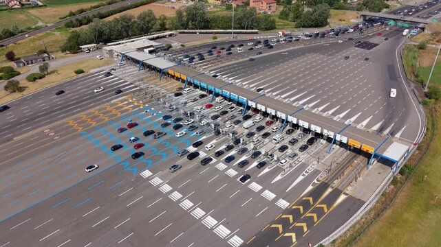Aerial view of heavy traffic moving through the Milano Sud toll plaza on the A1 motorway near Milan, showing multiple toll lanes, vehicles and major Italian road infrastructure.
