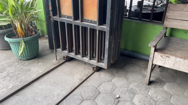 Traditional residential front yard with black sliding iron gate
