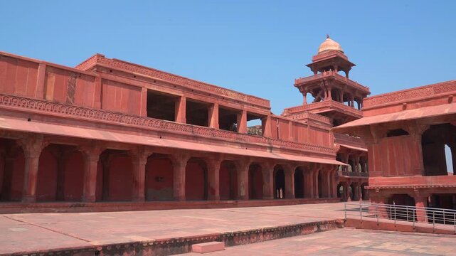 Slow pan left shot of the five story Panch Mahal tower and red sandstone palace pavilions at Fatehpur Sikri in Uttar Pradesh, India.
