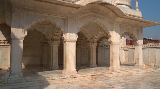 Tilt down shot from the white marble domes to the cusped arches of Nagina Masjid inside Agra Fort in Uttar Pradesh, India on a sunny day.