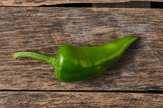 Top down view green chili pepper on rustic wooden plank.
