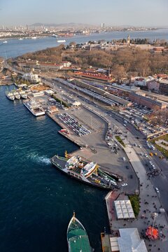 Aerial view of Topkapi Palace and the surrounding coastal area with ferries docked at the pier, urban streets, and buildings in Fatih, Istanbul, Turkey.
