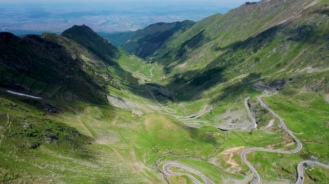 Aerial view of winding Transfagarasan mountain road across high peaks in Romania.