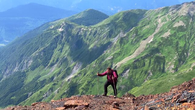 Solo hiker ascending front view on a rocky alpine slope in Svaneti, Georgia, showing mountain endurance, trekking technique, route difficulty, and outdoor training for active tourism campaigns