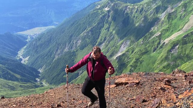 Male hiker ascending in front view on a rocky slope above Mestia, Svaneti, Georgia, outdoor scene for trekking tours, route planning, hiking fitness, mountain tourism, and adventure travel promotion