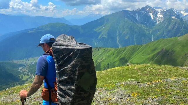 Male hiker trekking rear view across a highland trail above Mestia in Svaneti, Georgia, showing backpacking route access, outdoor endurance, mountain tourism, and active travel promotion in Caucasus