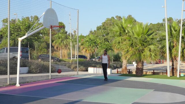 Athletic man scoring a basket on an outdoor court