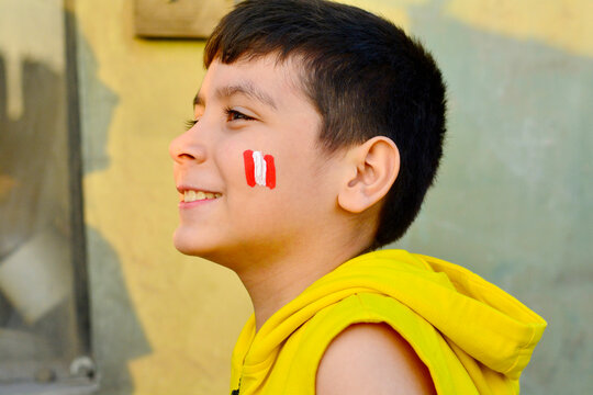 Excited little peruvian with national flag painted on cheeks.