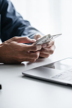 Businessman using mobile phone while working by connecting technology and synchronizing between devices