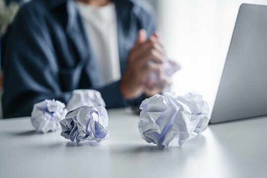 Man crumples failed idea paper in frustration during stressful office work