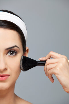 Beautiful woman applying blush