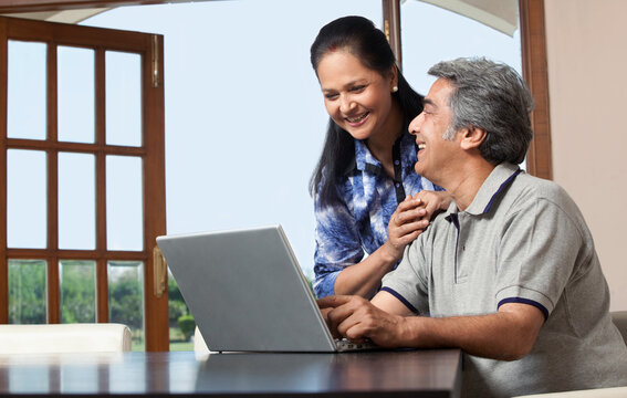 Old couple with a laptop enjoying
