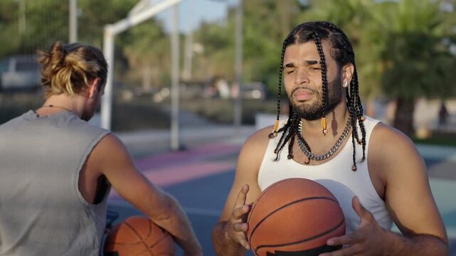 Two friends talking on an outdoor basketball court