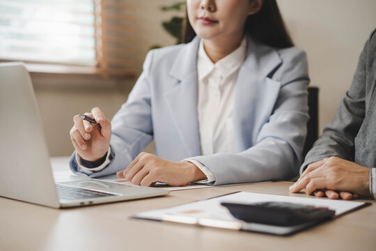 Financial advisors auditing data charts at office desk.