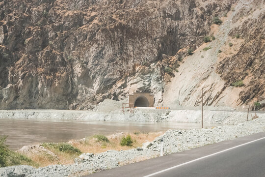 An asphalt road on the Pamir Highway in the Panj River Valley along the border of Afghanistan and Tajikistan, a road among rocky mountains