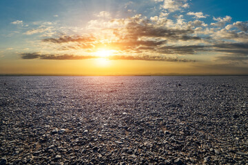 Naklejka premium Vast empty gravel desert under a dramatic sunset sky in Xinjiang, China