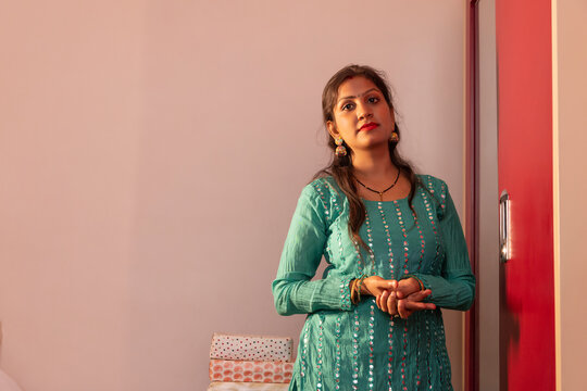 Woman standing thoughtfully in a cozy room