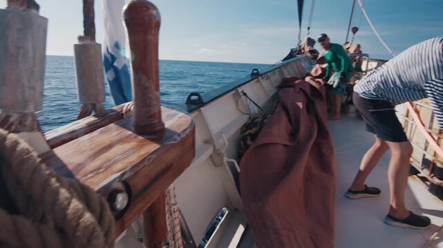 Crew work on the big sailing boat moving in the Atlantic Ocean under the sails