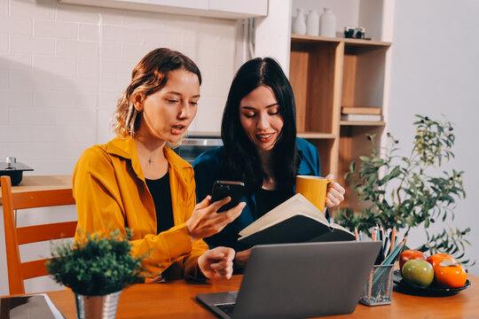 Portrait of military mother helping teen daughter with homework and eating lunch