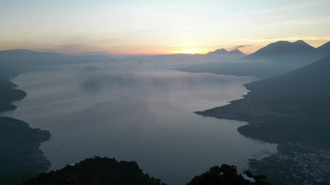 Aerial sunrise view over lake atitlan and volcanoes in guatemala.