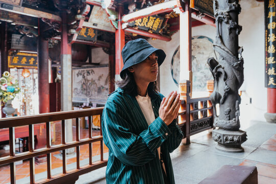 Person praying in temple, finding spiritual peace
