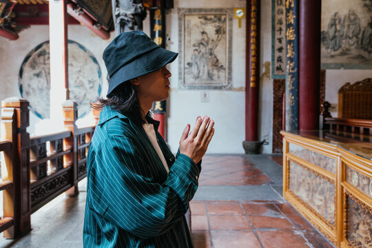 Man praying with hands clasped in traditional temple