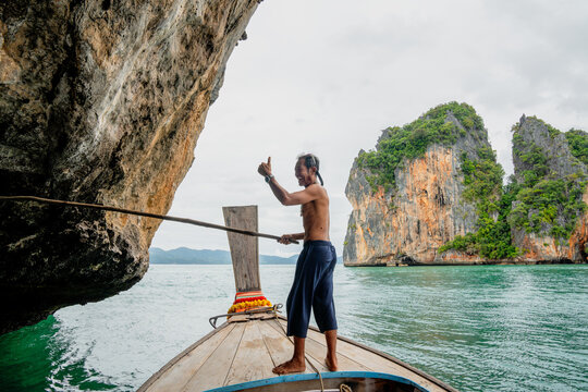 Thai longtail boatman giving thumbs up in phang nga bay