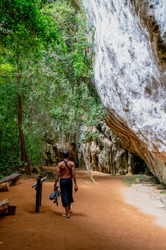 Man walking along limestone cliffs in tropical forest