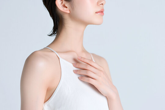 デコルテに手を添える若い日本人女性、首元と鎖骨の美しさを表現した美容・ボディケアイメージ