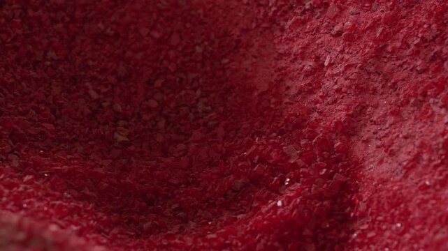 Heap of crushed red plastic granulate filling the frame at a Recycling Factory