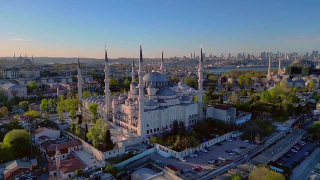 Sultan Ahmed Mosque, known as the Blue Mosque, standing prominently against a clear sky with the Istanbul cityscape and Bosphorus. Magic aerial view panorama drone overview