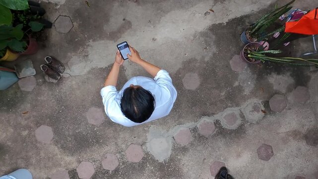 Top View of Young Man Looking at Smartphone Screen