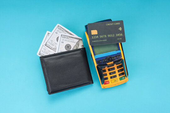 High Angle of Paper Currency in Wallet Positioned Next To Credit Card Reader on Light Background