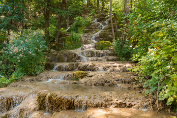 Water trickling over natural green mossy tufa rock cascades and travertine terraces at Bigar Waterfall near Kalna village at Stara Planina nature reserve in Serbia. © Dragan